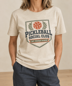 Natural cream t-shirt with a vintage Pickleball Social Club laurel crest badge